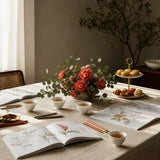 A long table set for a private Create and Sip group with coloring books, tea and fresh flowers